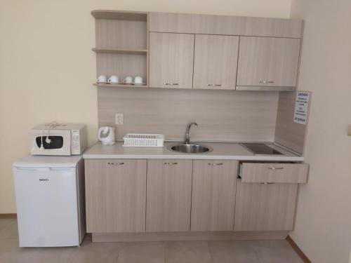 a small kitchen with a sink and a refrigerator at Stephanovy Guest House in Sozopol