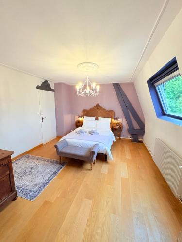 a bedroom with a bed and a chandelier at Le Manoir 1977 in Jaunay-Marigny