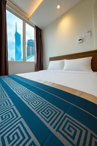 a bedroom with a bed with a blue and white blanket at Hotel 1915 Chinatown Kuala Lumpur in Kuala Lumpur