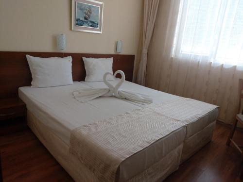 a white ribbon on a bed in a bedroom at Stephanovy Guest House in Sozopol