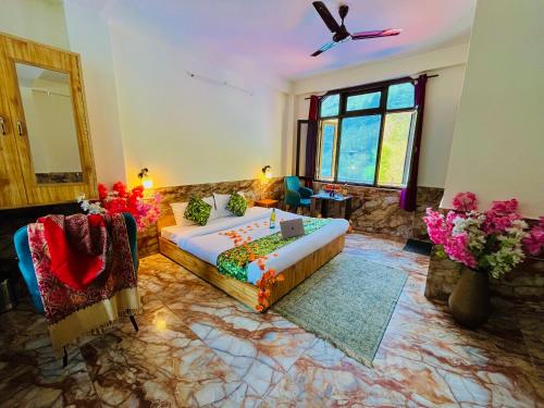 a bedroom with a bed and a couch and a window at Hotel Brownie River View in Kasol