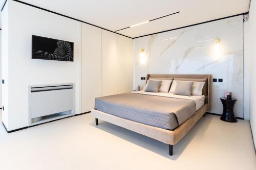 a bedroom with a bed in a white room at Extreme Luxury Villa in Punta Ala with Private Pool, SPA and Gym in Punta Ala