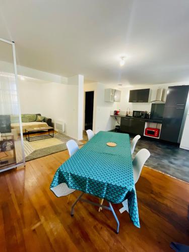 - un salon avec une table et des chaises vertes dans l'établissement Auprès du Rhône, à Saint-Vallier