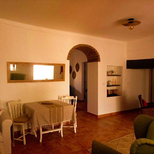 a dining room with a table and chairs in a room at Casa da Vila in Mourão