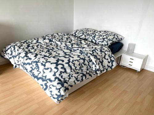 une chambre avec un lit avec une couette noire et blanche dans l'établissement Sur Erdre chambre et salle de bain, à Nantes