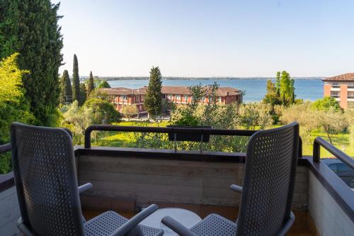 a balcony with chairs and a view of the water at Hotel Désirée - Garda Lake Collection in Sirmione