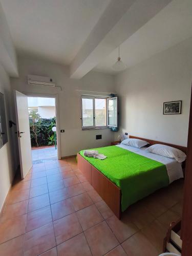 a bedroom with a green bed and a window at Anthos Residence sul mare in Cariati