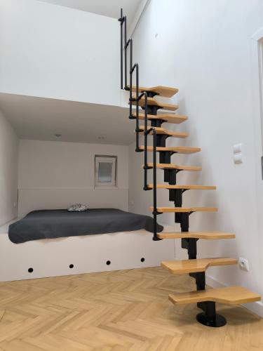 a spiral staircase in a room with a bed at Buda-city house in Trnávka