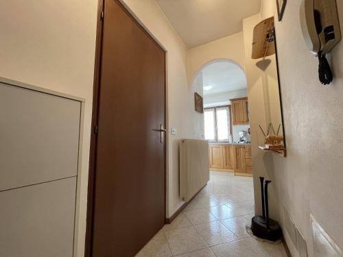 a hallway with a door to a kitchen with a refrigerator at 063 Bilocale, Carisolo in Carisolo