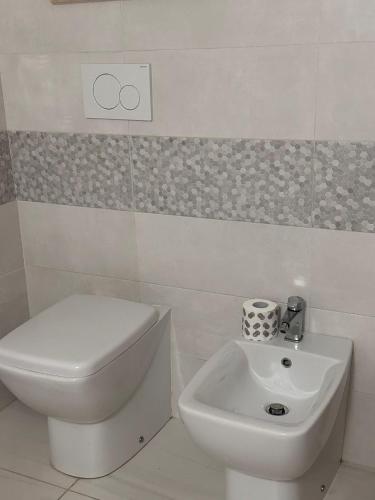 a white toilet and a sink in a bathroom at Fabiola home in Borgo Montenero