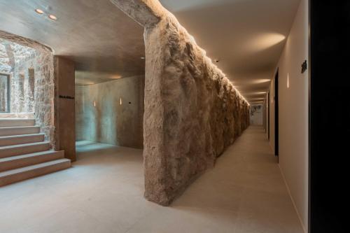 a hallway with a stone wall in a building at Noir Mykonos in Mýkonos City
