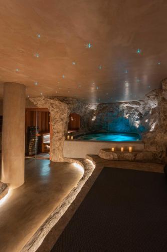a pool in a room with a stone wall at Noir Mykonos in Mýkonos City
