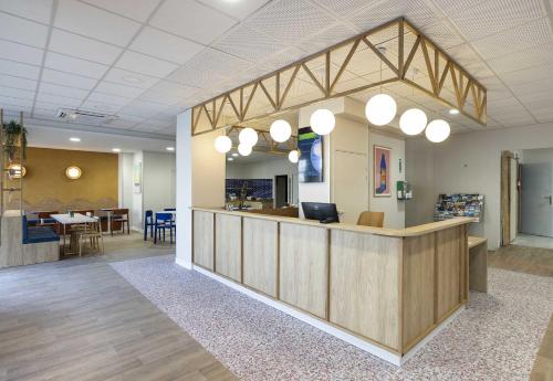 eine Bürolobby mit einer Rezeption und einem Essbereich in der Unterkunft B&B HOTEL Perpignan Centre in Perpignan