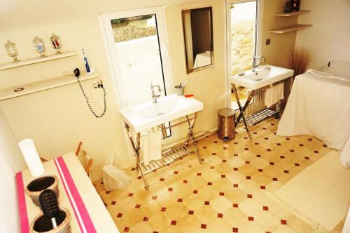 La salle de bains est pourvue de 2 lavabos, d'un lit et d'un miroir. dans l'établissement Superbe Mas en pierres de 350 m2 avec piscine pool house wifi parking gratuits, à Rochefort-du-Gard