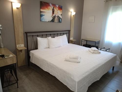 a bedroom with a bed with two towels on it at Aurora Premium Hospitality in Parga