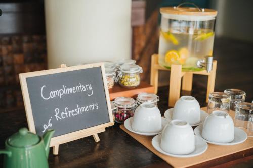 a table with cups and saucers and a sign at The Kala in Amphoe Koh Samui
