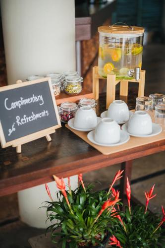 a table with cups and saucers and a sign at The Kala in Amphoe Koh Samui