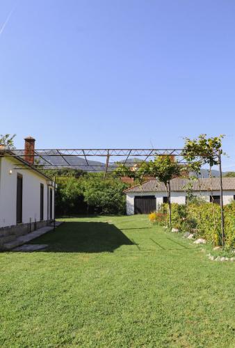 a yard with green grass and a white house at Casa L in Ulcinj