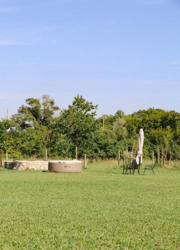 a horse standing in a field with an umbrella at Casa L in Ulcinj