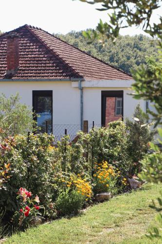 a house with a garden of flowers in front of it at Casa L in Ulcinj