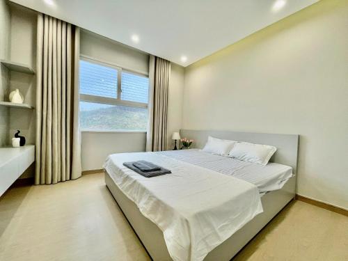 a bedroom with a large bed with a window at By's House- Căn hộ View biển Hạ Long in Ha Long