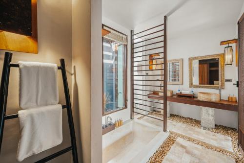 a bathroom with a shower and a tub and a sink at The Kala in Amphoe Koh Samui