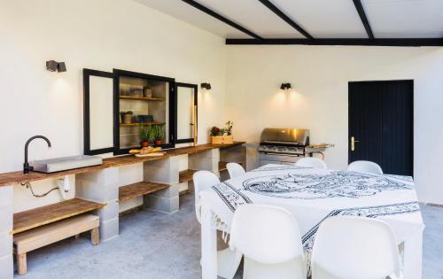 a dining room with a table and white chairs at Villa Margarita in Palma de Mallorca