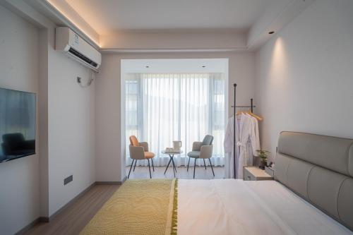 a bedroom with a bed and chairs in a room at Daishan Mountain and Sea Cloud Homestay Sunrise Seaview Bed and Breakfast in Zhoushan