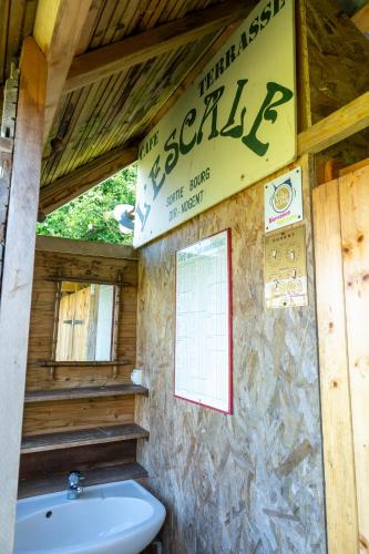 une salle de bain avec des toilettes blanches et un lavabo dans l'établissement Manoir du Bois Joly - Roulotte Gitane, à Margon