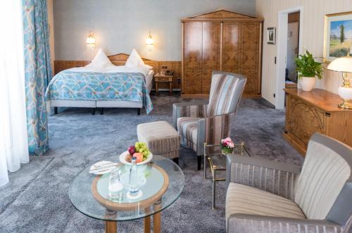 a hotel room with a bed and a table and chairs at Privat-Hotel Villa Aurora in Bad Neuenahr-Ahrweiler