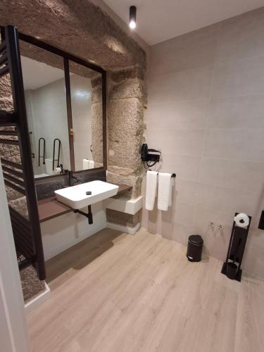 a bathroom with a sink and a mirror at Casa da Praza in Lobios