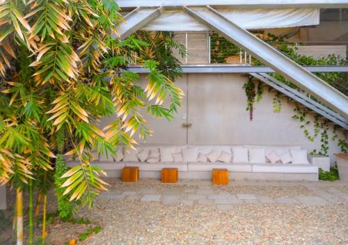 a room with a white couch under a building with trees at Casa Cascada - Adults Only in Puerto Escondido