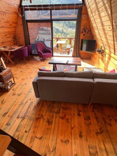 a living room with a couch and a large window at İrem Bungalow in Trabzon
