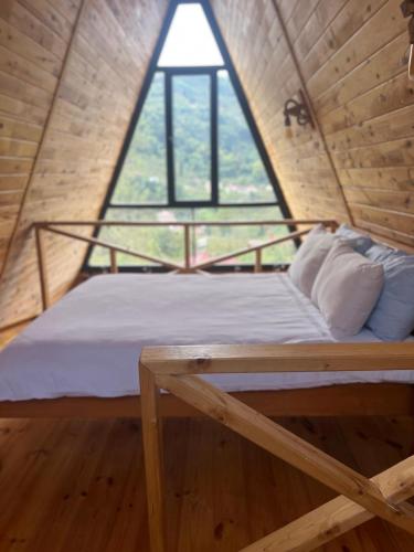 a bed in a room with a large window at İrem Bungalow in Trabzon