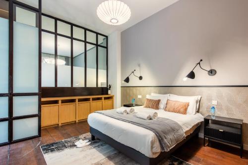 - une chambre avec un grand lit avec deux chiens dans l'établissement Sweett - Artois Haussman, à Paris