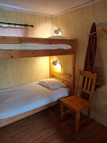 a bedroom with two bunk beds and a chair at Mjölby Vandrarhem in Mjölby