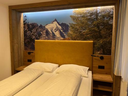 a bedroom with a window with a mountain view at Hotel - Restaurant - Sonnblick in Heiligenblut