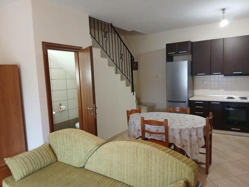 a living room with a table and a kitchen at Autonomous Maisonette in Nikiti