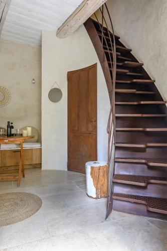 un escalier dans une pièce avec une porte en bois dans l'établissement Gîte de charme face au Luberon, avec Jacuzzi, à Oppède