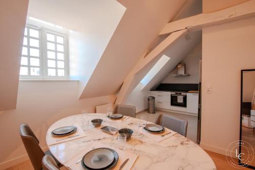 une cuisine et une salle à manger avec une table et des chaises dans l'établissement Le Martroi - Hypercentre avec vue - 55m 1 chambre, à Orléans