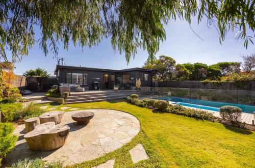 Quay-Walk to beach Gas Heated Pool, Spa, Trampoline في بليرغوري: منزل به حديقة خلفية وحمام سباحة