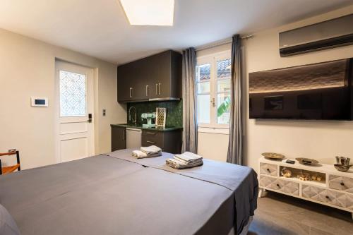 a bedroom with a large bed and a kitchen at The Secret Garden - Courtyard & Private Pool Villa in Kalamata