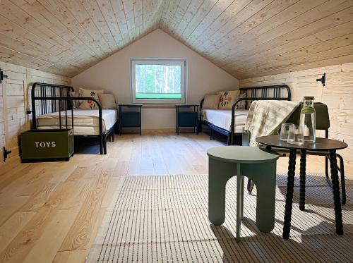a room with two beds and a table in a attic at Leśne Anioły in Czarna