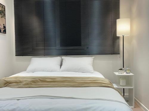 a bedroom with a bed with a window with black blinds at Harangae in Seoul