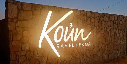 a sign that says krum on a stone wall at Koun Ras ElHikma كون راس الحكمة in Ras Elhekma