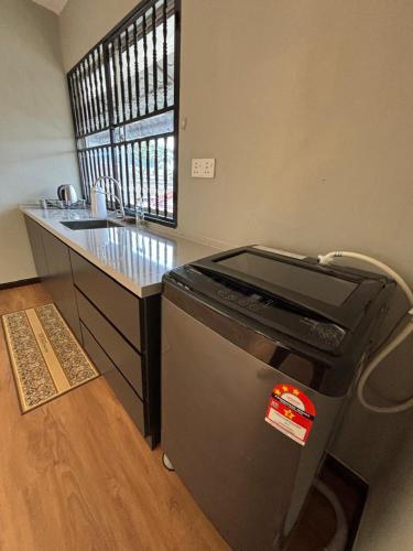 a kitchen with a dishwasher next to a counter at 2-16 pax 5BR, 4 bathrooms, 5km to TC beach in Kuantan