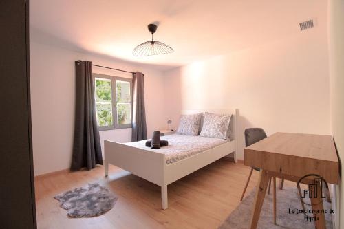 a bedroom with a bed and a table and a window at Le Nordet Vert in Albi