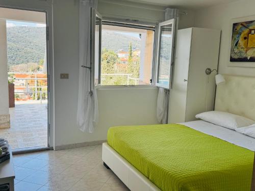 a bedroom with a green bed and a window at Casa Mare in Rabac