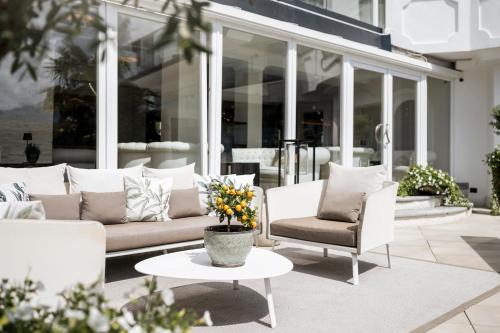 a patio with a couch and two chairs and a table at Small & Beautiful Hotel Gnaid in Tirolo