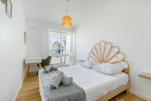 une chambre blanche avec un grand lit et une fenêtre dans l'établissement L'Océanide - Vue mer - Parking, à Saint-Hilaire-de-Riez